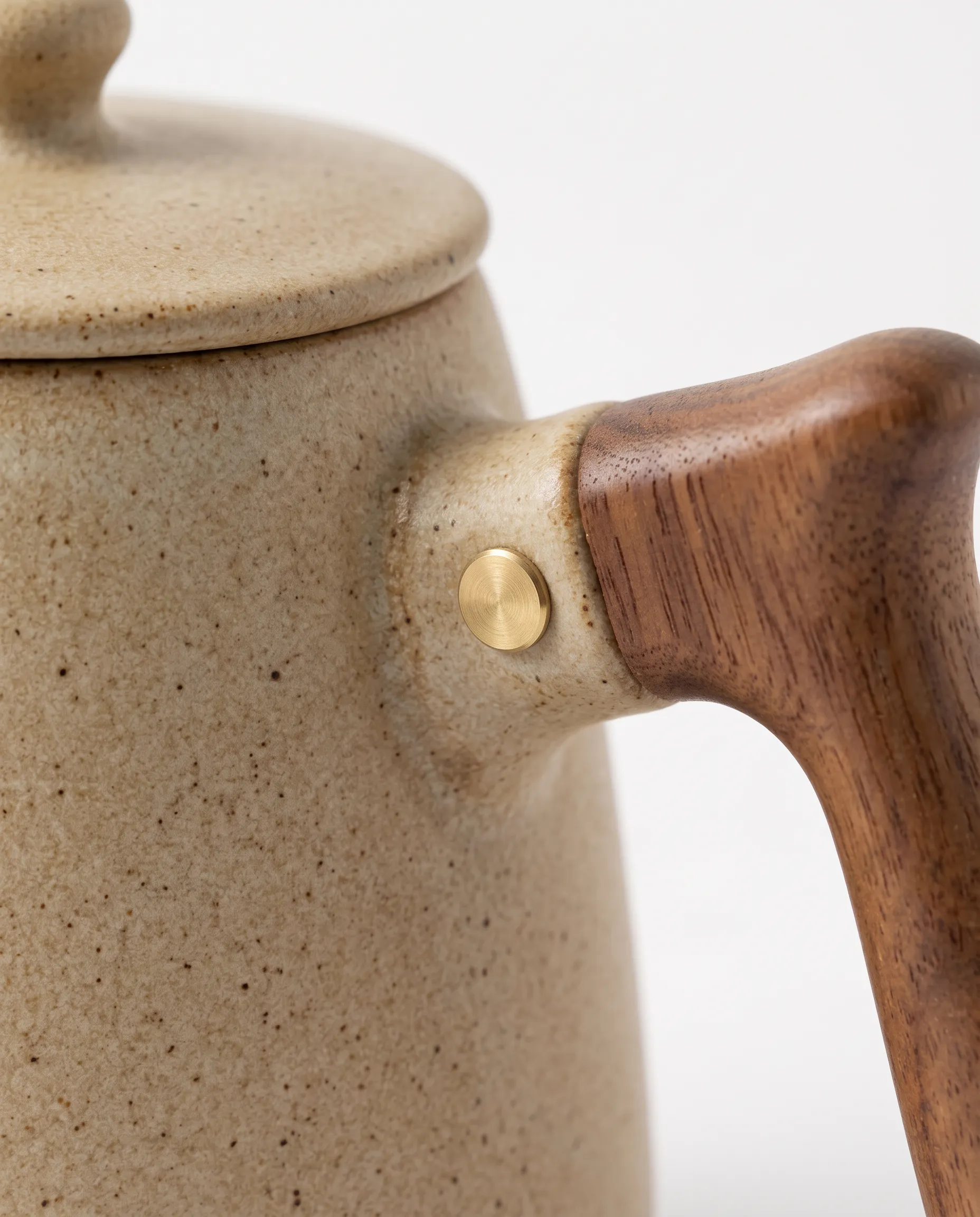 Close view of the kettle’s walnut handle and brass pin